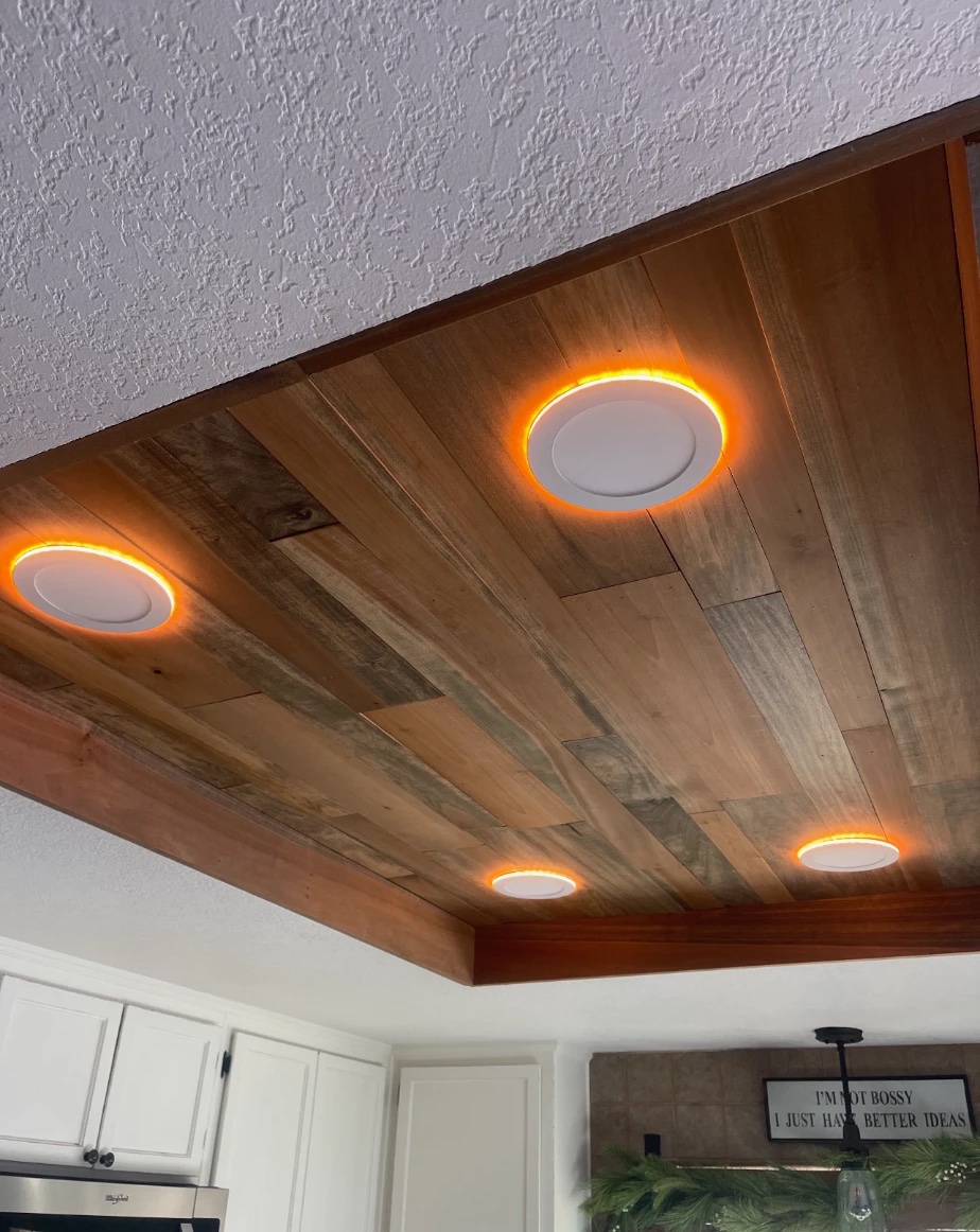 Wood plank ceiling inset over a kitchen with glowing surface-mount LED lights