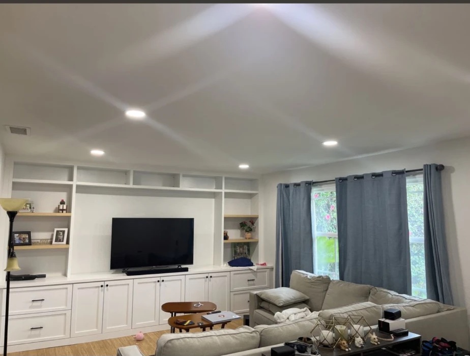 Living room ceiling with six new recessed lights above a custom built-in media wall